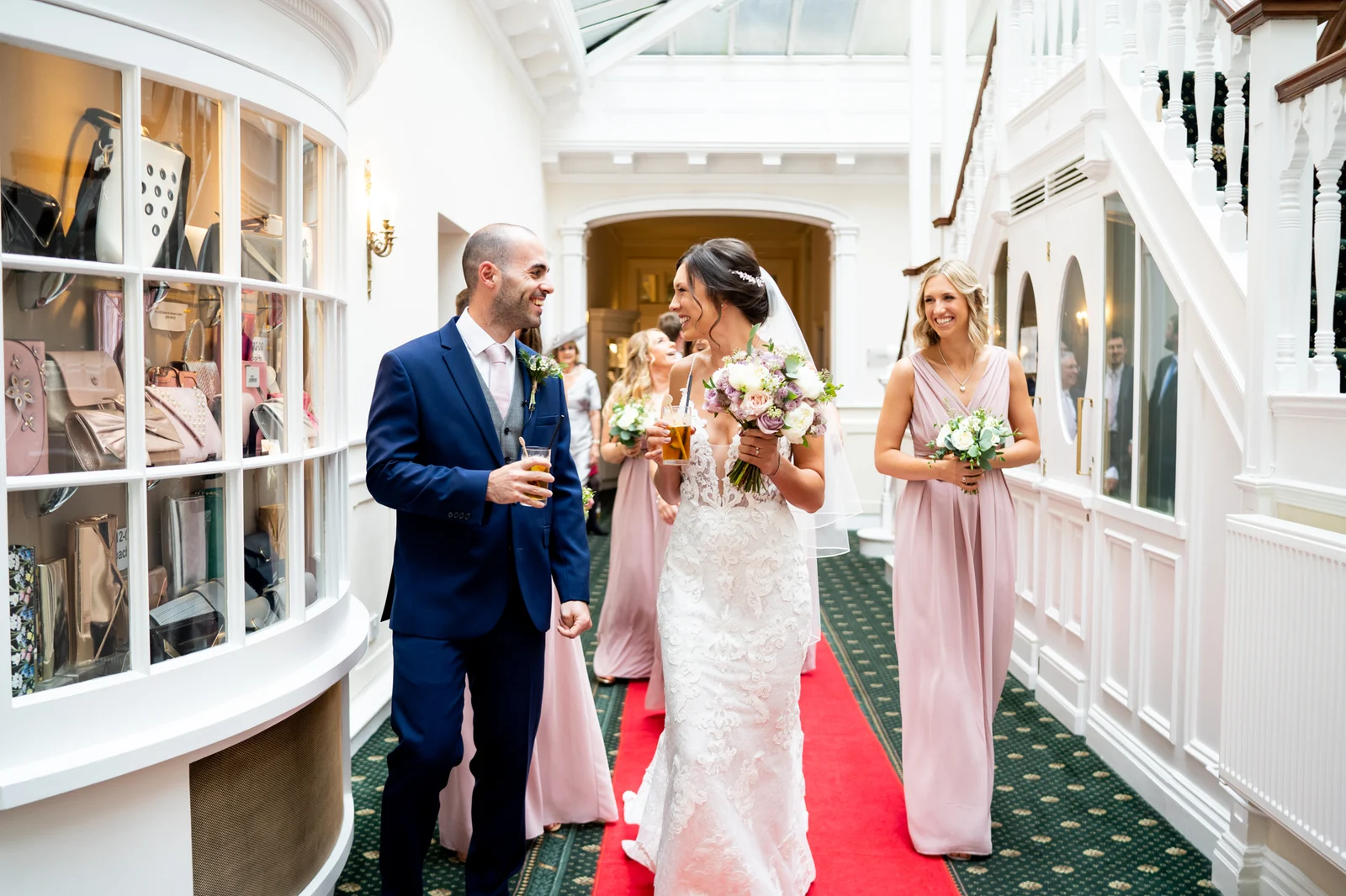 A wedding party walking through a sunlit arcade