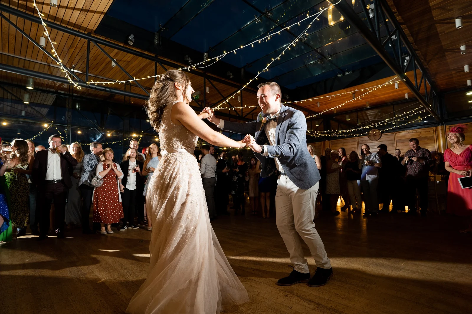 A couple's first dance beneath wedding lights